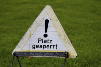 Sign with the inscription PLACE BLOCKED on a sports field (symbol image)