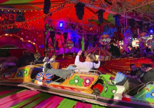 People on the Musik-Express ride at the All Saints Fair, the biggest old town fair in Europe,