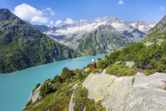Mountaineers in front of picturesque mountain landscape, turquoise-blue mountain lake