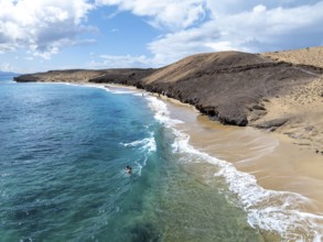 Coast with Playa Caleta del Congrio beach and blue sea, arid landscape of Los Ajaches Natural Park,