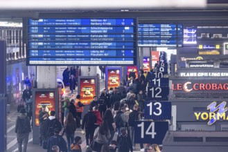 Travelers at the main train station, passengers and departure board at Stuttgart main station.