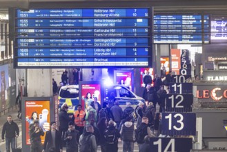 Travelers at the main train station, passengers and departure board at Stuttgart main station.