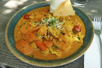 Asian cuisine, mixed vegetables, carrots, cauliflower, bamboo, cherry tomatoes, curry sauce,