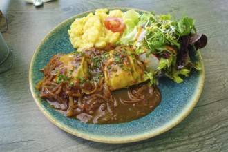 Swabian cuisine, ravioli with potato salad, gravy with onions, colorful salad, mixed salad side