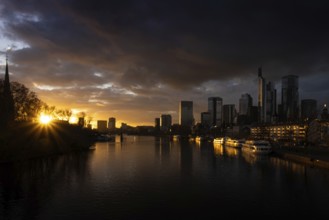 The sun sets behind the Main and bathes Frankfurt's banking skyline in orange-yellow light, Alte