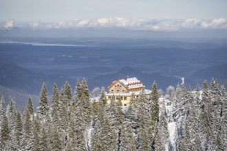 Snowy forest and Kreuzeckhaus mountain hut in the Garmisch Classic ski area in winter, Wetterstein