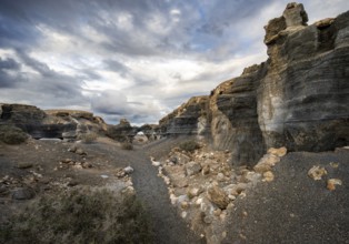Eroded rock formations, volcanic landscape with dramatic cloudy skies, Ciudad Estratificada or Los