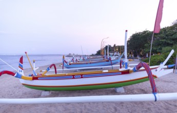 Colourfully painted outrigger fishing boats, (Junkung), on Sanur beach, Bali, Indonesia