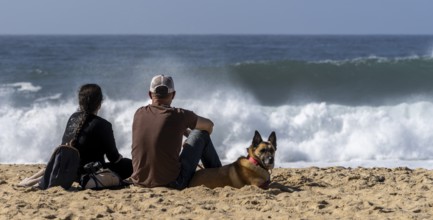 Tourists watch the waves of the Atlantic on the rocky plateau of Sito, also known as Forte São