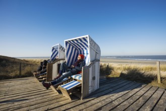 Beach chairs in the dunes and blue sky in winter, Spiekeroog, East Frisian Islands, Lower Saxony,
