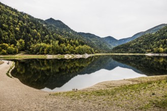 Picturesque mountain lake with water reflections in autumn, Lac de Kruth-Wildenstein, Kruth,