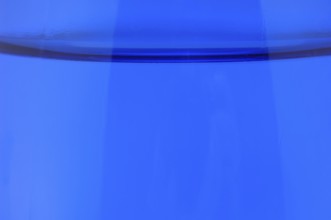 Glass with mineral water, small carbonated pearls on the edge of the glass, drinking water