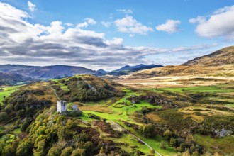 Autumn colours over Castell Dolwyddelan and Eryri Mountains from a drone, Snowdonia, Conwy County