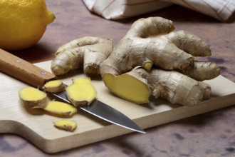 Ginger, ginger root cut with ginger slices on wooden boards