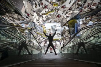 Young man on a stairway, entrance to a shopping center with many mirrors, Tokyu Plaza Omotesando