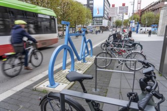 Bicycle parking spaces, with so-called leaning bars and a large blue bicycle silhouette, to make