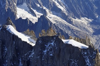 Rugged rocks jut out of a snow-covered mountain, viewing platform, Aiguille du Midi mountain