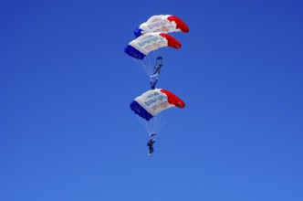 Skydivers during an aerial acrobatic performance as part of an air show at the Fliegerbergfest of