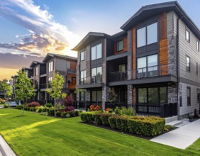 Modern apartment building with balconies and well-kept landscaping at sunset, Modern multifamily