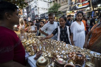 People shop for bronze and other metal items at a roadside stall on Dhanteras, in Guwahati, Assam,