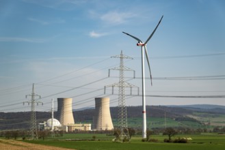 Distant view of the Grohnde nuclear power plant, with wind turbine, electricity pylons and power