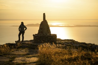 Woman standing next to cairn and looking at the sea, Rørsethornet stone staircase, with 3292 steps