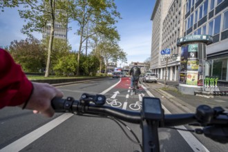 Riding a bike in a bike lane, marked in red to attract the attention of motorists, between 2 lanes,