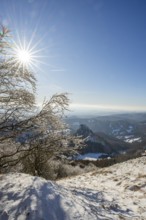 View over the hills and valleys from the mountain with hoarfrost on the branches in winter, Vápec,