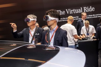 Mercedes trade fair stand with virtual presentation. Trade fair visitors with 3D glasses. The
