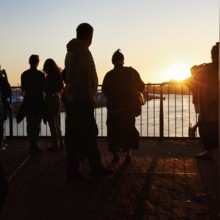 Crowd enjoying the view from the Elbphilharmonie over the Elbe at sunset, silhouettes, Plaza