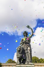 Colourful balloons rise high above the statue of Bavaria into the white-blue sky, grand finale of