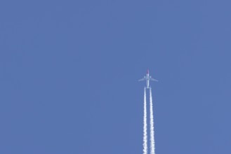 Boeing 737 jet passenger aircraft of Norweign Air with a vapour trial or contrail behind flying in