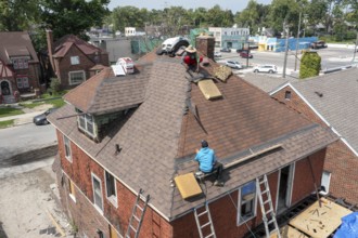 Detroit, Michigan - Workers re-roof a house they are remodeling in the Morningside neighborhood