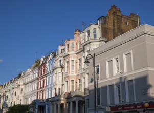 Terraced houses, townhouses with different, colourfully painted facades under a blue sky,