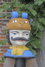 Colourful Swedish head as a landmark, historic wooden head with face and four eyes, tree house, Old