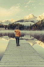 Young woman at Lake Staz near Sankt Moritz in the Engadine in Switzerland. Morning atmosphere with