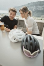 Young man taking a coffee break while riding his racing bike on Lake Garda. Sunny weather and dolce