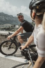 Woman and man cycling on Lake Garda in Italy. Sunny weather and dolce vita