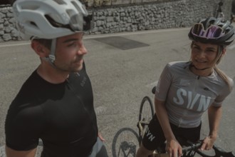 Woman and man cycling on Lake Garda in Italy. Sunny weather and dolce vita