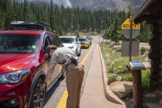 Colorado Springs, Colorado - A Pikes Peak ranger checks the temperature of brakes on a car