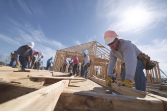 Collage of construction workers building homes, AI generated