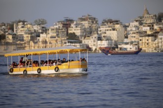 Excursion boats on Lake Pichola, behind the old town in the evening light, Udaipur, Rajasthan,