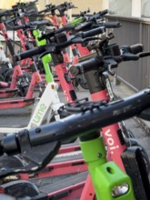 Many rental e-scooters parked on a pavement in Wuppertal, Germany