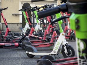 Many rental e-scooters parked on a pavement in Wuppertal, Germany