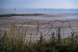 Barbed wire in front of Phoenix Caissons, caissons, concrete boxes, were used in the sea as