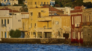 Old, colourful buildings on the water illuminated by the evening sun, quiet coastal feeling, Agia