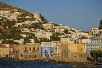 Coastal town with colourful houses along the water, church on the hill above the town, Agia Marina,