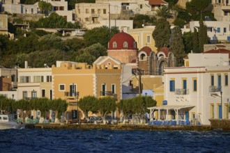 Colourful houses on the waterfront with a church and trees, Greek coastal town ambience, Agia