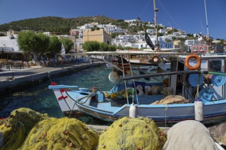 Fishing boats in the harbour of a Greek village, surrounded by fishing nets and blue sky, Agia
