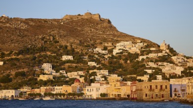 Panteli Fortress, Greek village on a hillside at dusk, historic buildings in front of a fortress